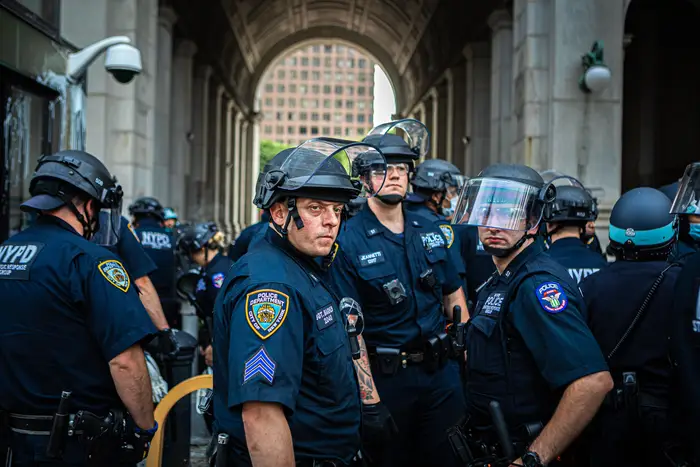 A group of NYPD officers watch protesters outside of City Hall in early July.